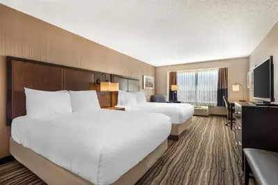 a hotel room with two beds and a television at Best Western PLUS Calgary Centre Inn in Calgary