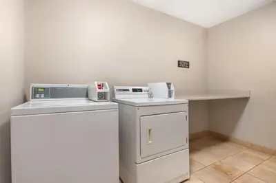 a small laundry room with a washer and dryer at Best Western PLUS Calgary Centre Inn in Calgary