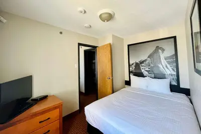 a hotel room with a bed and a television at Super 8 by Wyndham Grande Prairie in Grande Prairie