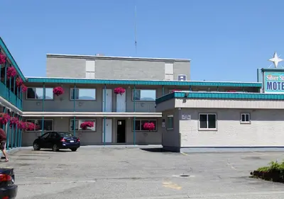 a building with a car parked in a parking lot at Silver Star Motel in Vernon