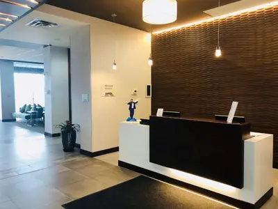 a lobby with a reception desk with a person on the counter at Wingate by Wyndham Kamloops in Kamloops