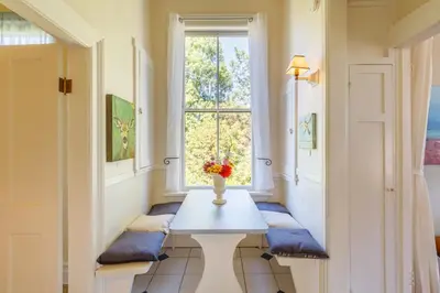 a hallway with a table and a window at Fairholme Manor Inn in Victoria