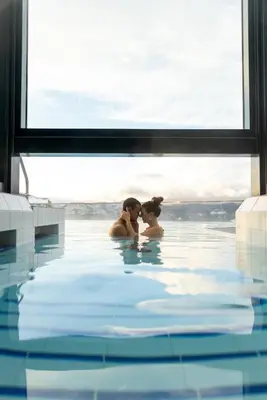two women sitting in a swimming pool at Sparkling Hill Resort and Spa - Adults-Only Resort in Vernon