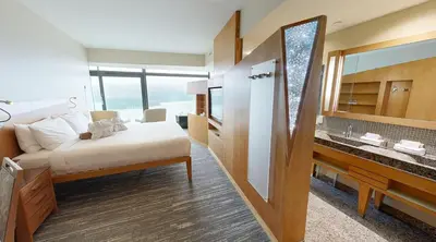 a bedroom with a bed and a sink and a mirror at Sparkling Hill Resort and Spa - Adults-Only Resort in Vernon