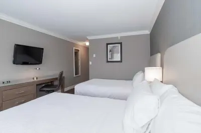 a hotel room with two beds and a desk at Sandman Hotel Langley in Langley