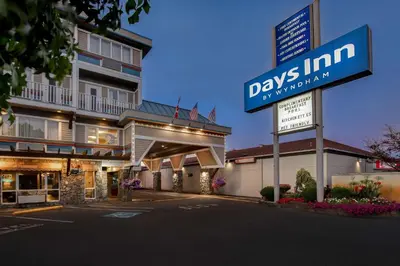 a hotel with a sign in front of a building at Days Inn by Wyndham Victoria Airport Sidney in Sidney