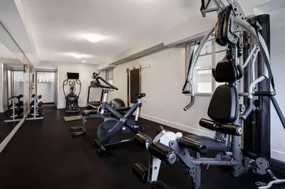 a gym with several treadmills and exercise bikes at Days Inn by Wyndham Victoria Airport Sidney in Sidney