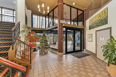 a lobby of a building with potted plants at The Bedford Regency Hotel in Victoria