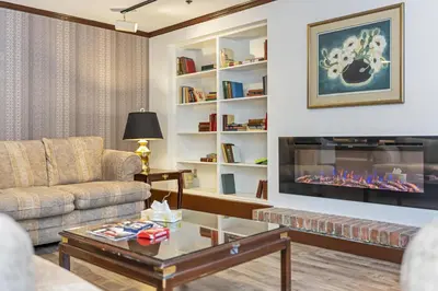 a living room with a couch and a fireplace at The Bedford Regency Hotel in Victoria