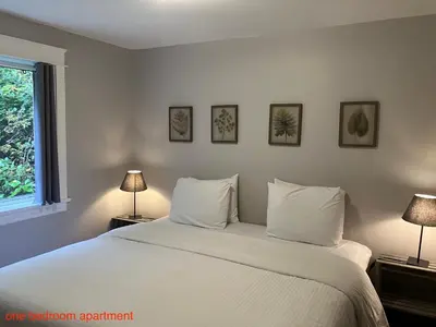 a bedroom with a large white bed with two lamps at Sienna's Tree House (Tall Trees And Salty Breeze) in Tofino
