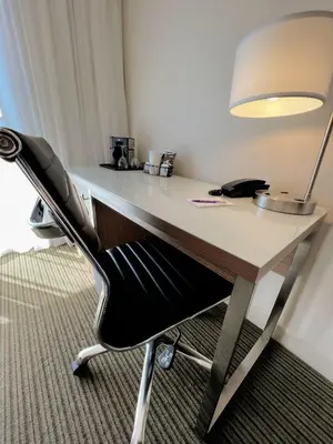 a desk with a chair and a lamp on it at Coast Capri Hotel in Kelowna