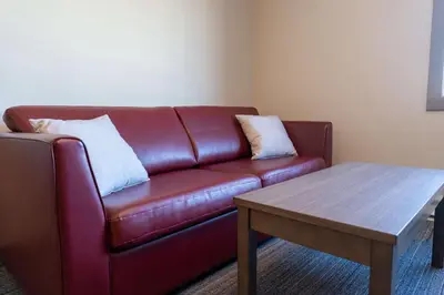 a brown leather couch in a living room with a table at Best Western Gold Rush Inn in Whitehorse