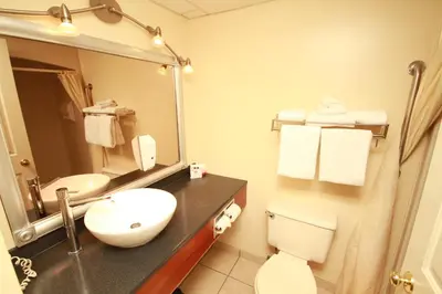 a bathroom with a sink and a toilet and a mirror at Best Western Gold Rush Inn in Whitehorse