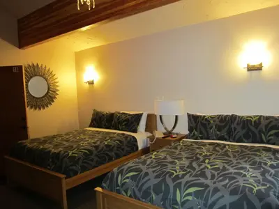 a hotel room with two beds and a mirror at The Lodge At Skeena Landing in Terrace