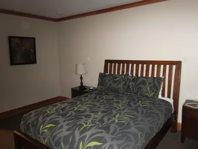 a bedroom with a bed with a green comforter at The Lodge At Skeena Landing in Terrace