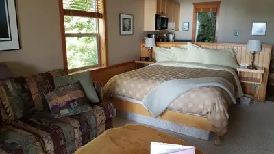 a bedroom with a bed and a couch at Reef Point Oceanfront Bed and Breakfast in Ucluelet