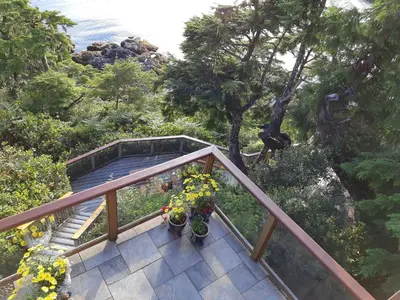 a staircase with flowers on it next to the ocean at Reef Point Oceanfront Bed and Breakfast in Ucluelet