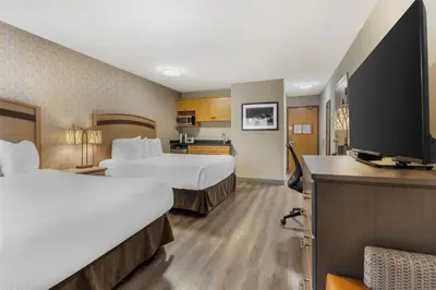 a hotel room with two beds and a flat screen tv at Best Western Plus Country Meadows Inn in Aldergrove