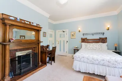 a bedroom with a bed and a fireplace at Beaconsfield Bed and Breakfast - Victoria in Victoria