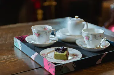 a tray with a piece of cake and tea cups at Beaconsfield Bed and Breakfast - Victoria in Victoria