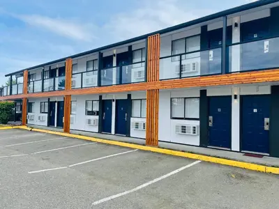 a building with blue doors in a parking lot at Coast Courtenay Hotel in Courtenay