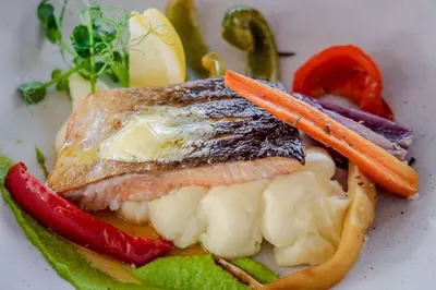 a plate of food with a piece of fish and vegetables at Hilton Vancouver Airport in Richmond