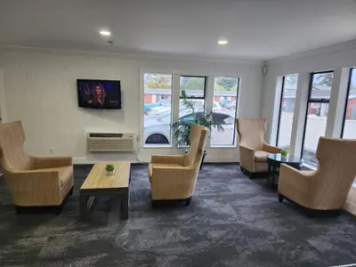 a waiting room with chairs and a table at Alpine Inn Abbotsford in Abbotsford