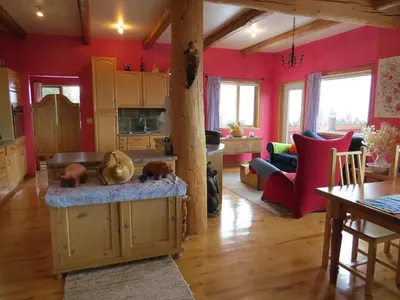 a living room with red walls and wooden floors at Tschurtschenthaler Lodge in Golden
