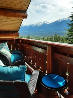 a balcony with chairs and a table and mountains at Tschurtschenthaler Lodge in Golden