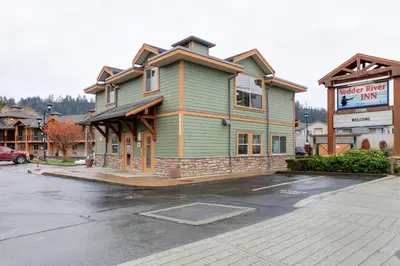 a building in a parking lot next to a store at Vedder River Inn in Chilliwack