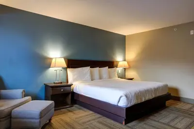 a hotel room with a bed and a chair at Vedder River Inn in Chilliwack