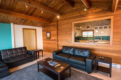 a living room with leather furniture and a kitchen at Ocean Resort in Oyster Bay