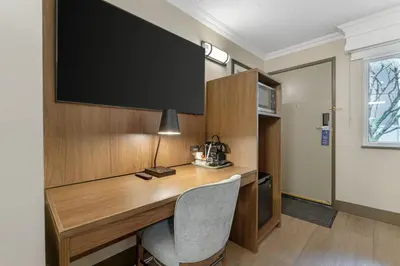 a desk in a room with a television on the wall at Best Western PLUS Burnaby Hotel in Burnaby