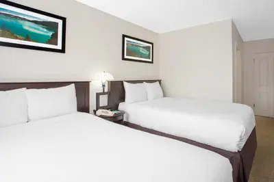 two beds in a hotel room with white sheets at Barriere Motor Inn-BMI in Barrière