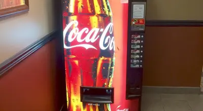 a cocacola soda machine is next to a wall at Barriere Motor Inn-BMI in Barrière