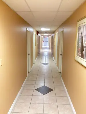 an empty hallway in a building with a tile floor at Barriere Motor Inn-BMI in Barrière