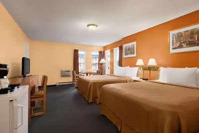 a hotel room with two beds and a flat screen tv at Travelodge by Wyndham Quesnel BC in Quesnel