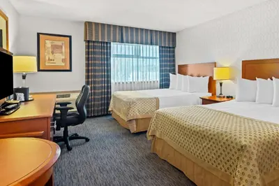a hotel room with two beds and a desk at Best Western PLUS Langley Inn in Langley