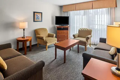 a living room with furniture and a flat screen tv at Best Western PLUS Langley Inn in Langley