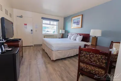 a hotel room with a bed and a television at Empire Inn & Suites in Red Deer