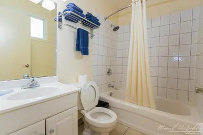 a bathroom with a sink and a toilet and a tub at Empire Inn & Suites in Red Deer