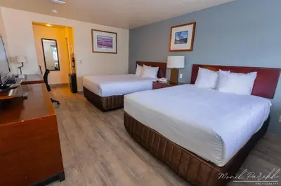 a hotel room with two beds and a television at Empire Inn & Suites in Red Deer