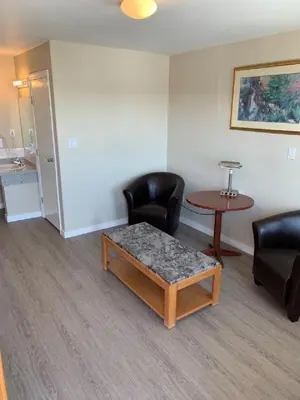 a waiting room with two chairs and a table at Red Deer Inn & Suites in Red Deer