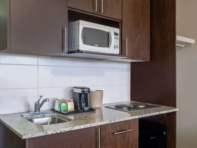 a kitchen with a sink and a microwave at Travelodge by Wyndham Wetaskiwin in Wetaskiwin