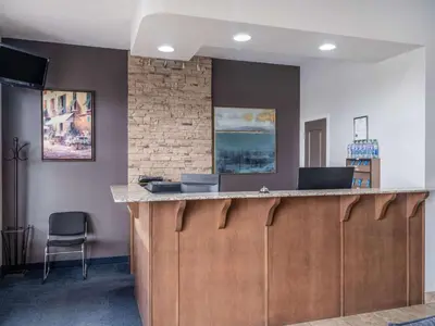 a lobby with a bar with a chair in a room at Travelodge by Wyndham Wetaskiwin in Wetaskiwin