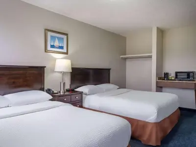 a hotel room with two beds and a table at Travelodge by Wyndham Wetaskiwin in Wetaskiwin