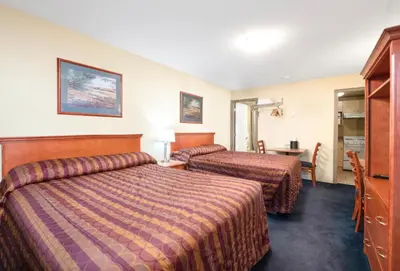 a hotel room with two beds and a table at Linda Vista Motel in Surrey