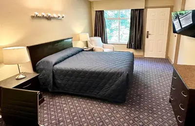 a hotel room with a bed and a television at Linda Vista Motel in Surrey