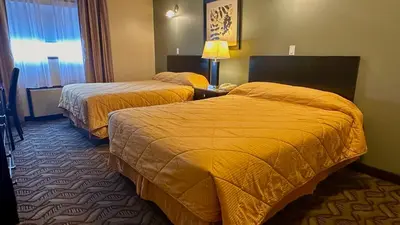 a hotel room with two beds and a window at Lacombe Motor Inn in Lacombe