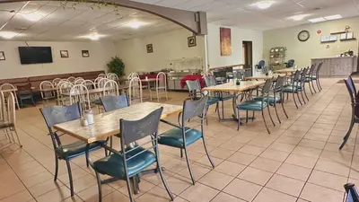 a restaurant with tables and chairs in a room at Lacombe Motor Inn in Lacombe